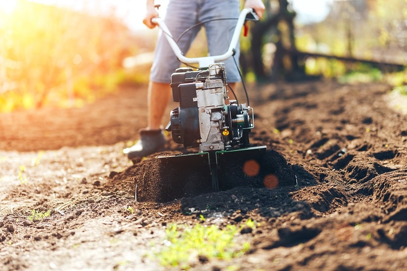 Gartenboden wird mit einem Gartenkultivator aufgelockert