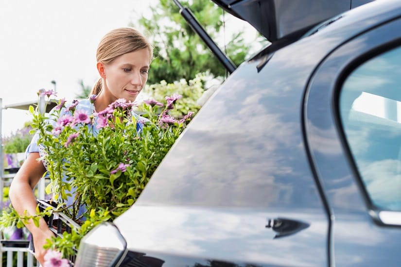 Eine Frau nutzt ihr Auto als Gartentransporter