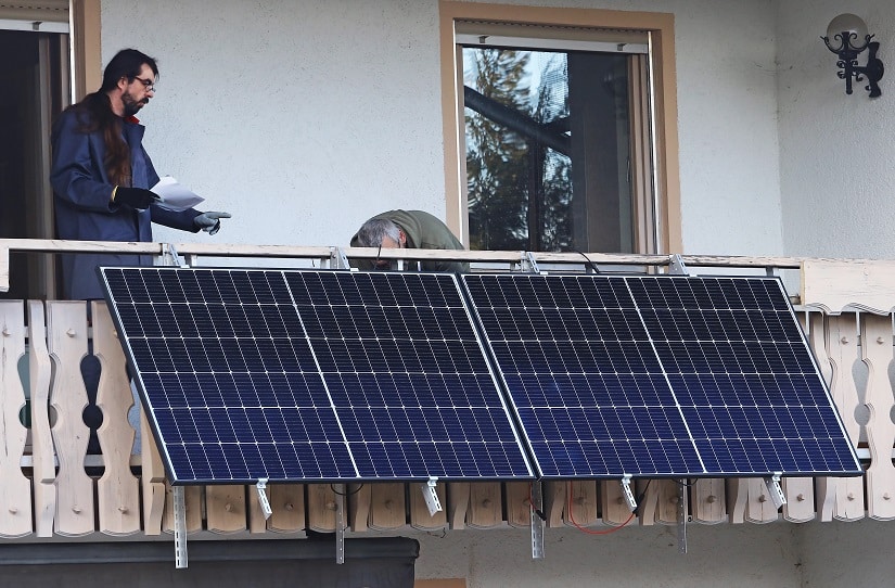 Zwei Männer installieren einen Balkonkraftwerk zu Hause.